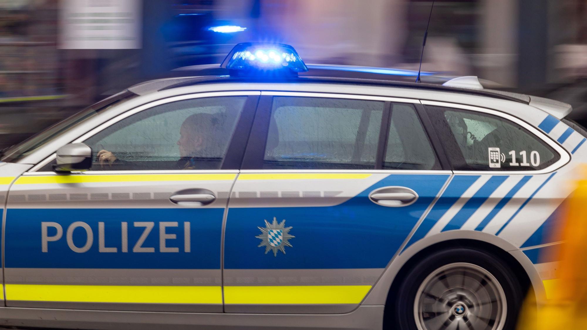 Ein Polizeiwagen fährt mit Blaulicht durch die Stadt.