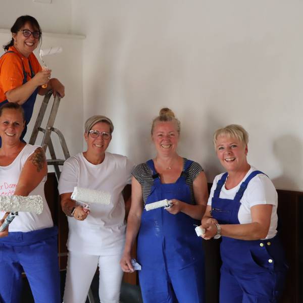 Mehrere Frauen der 1. Hürther Damengarde „Hürther Hätzje“ sind mit Pinseln, Rollen und Farbe auf dem Foto zu sehen.