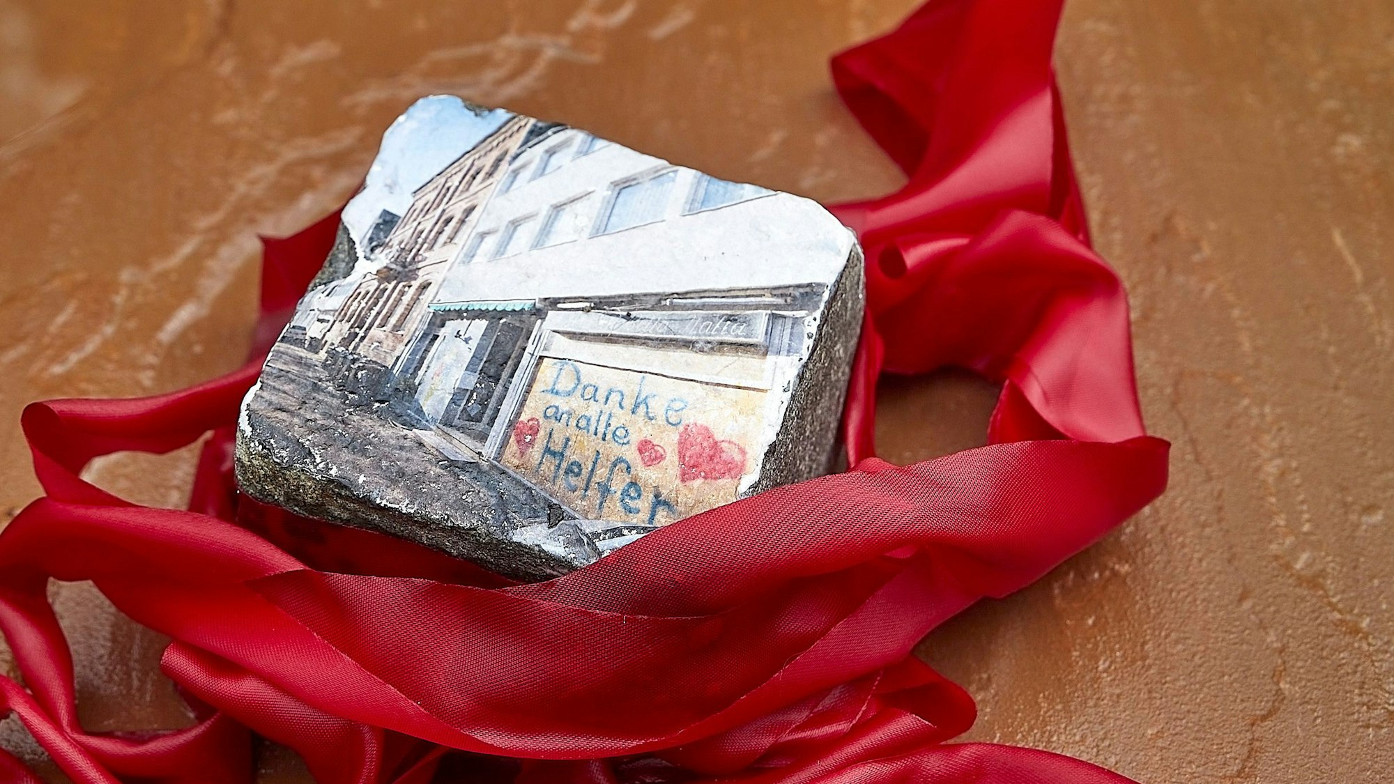 Zu sehen ist ein Pflasterstein mit einem Foto aus dem Wiederaufbau.