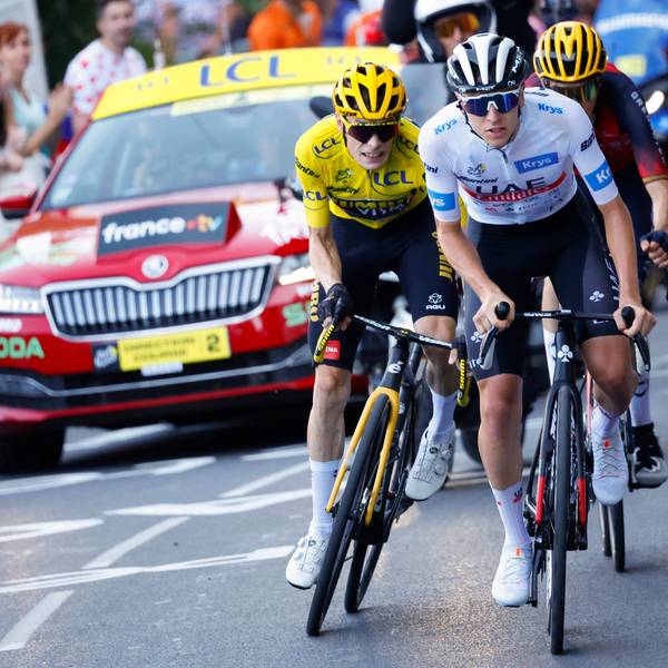 Der Slowene Tadej Pogacar in einem Anstieg bei der Tour de France vor dem Träger des Gelben Trikots, Jonas Vingegaard. Hinter ihnen fährt der Spanier Carlos Rodriguez, unmittelbar vor einem offiziellen Fahrzeug der Frankreich-Rundfahrt.