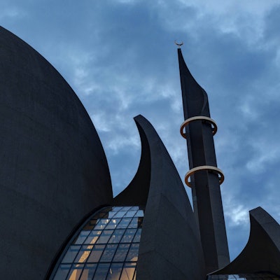 Die beleuchtete Zentralmoschee in Ehrenfeld vor nachtblauem Himmel