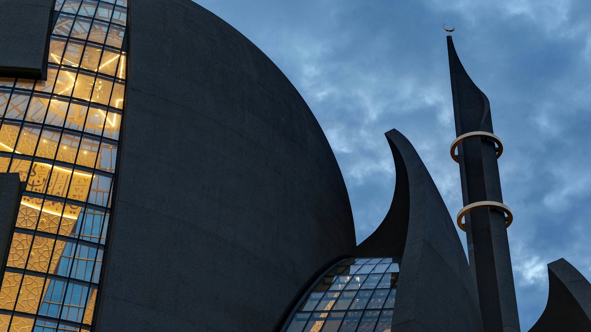 Die beleuchtete Zentralmoschee in Ehrenfeld vor nachtblauem Himmel