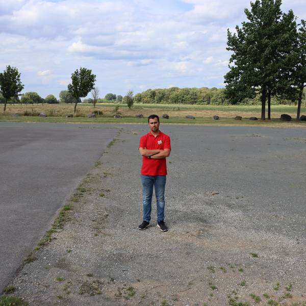 Ein Mann steht an einem Betonplatz.