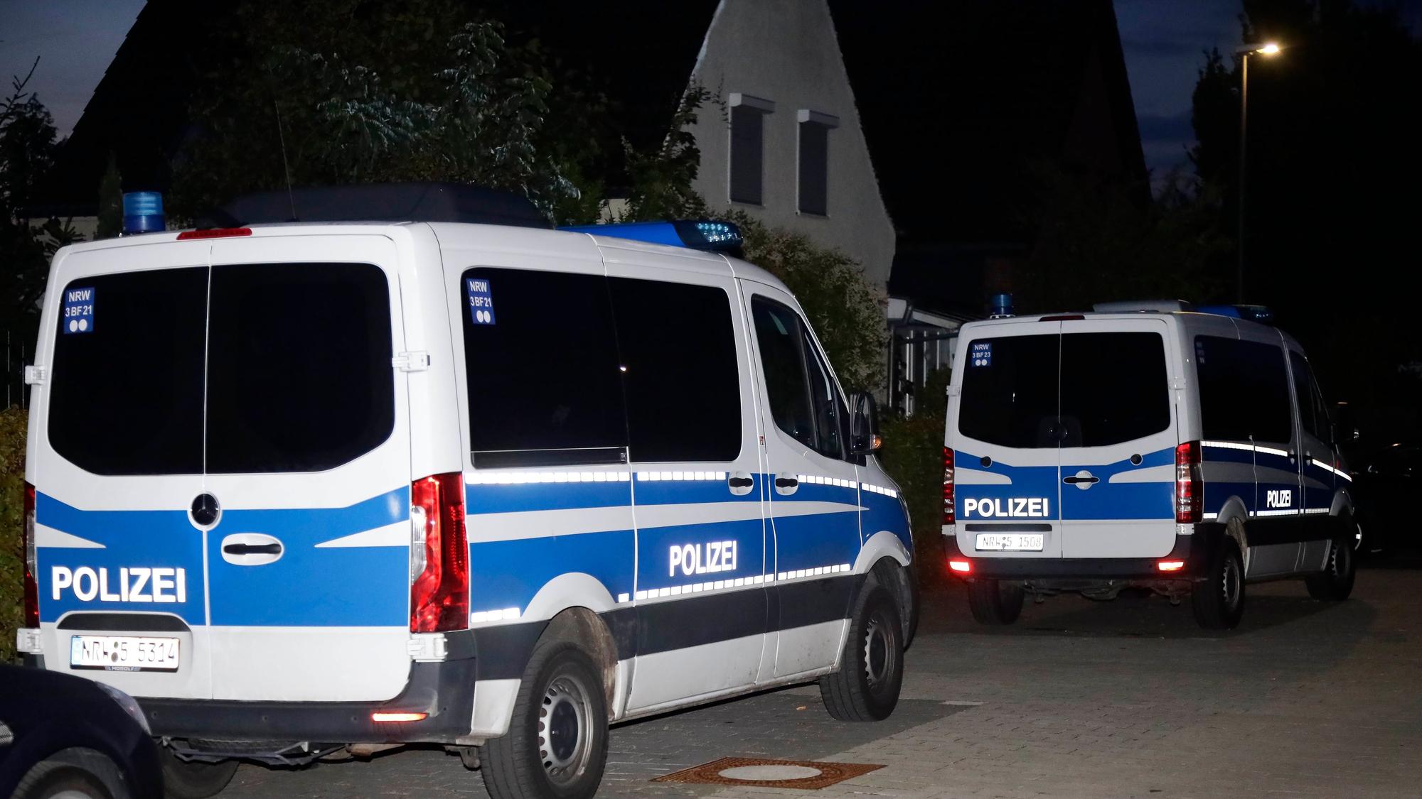 Mehrere Einsatzwagen der Polizei stehen vor einem Wohnhaus.