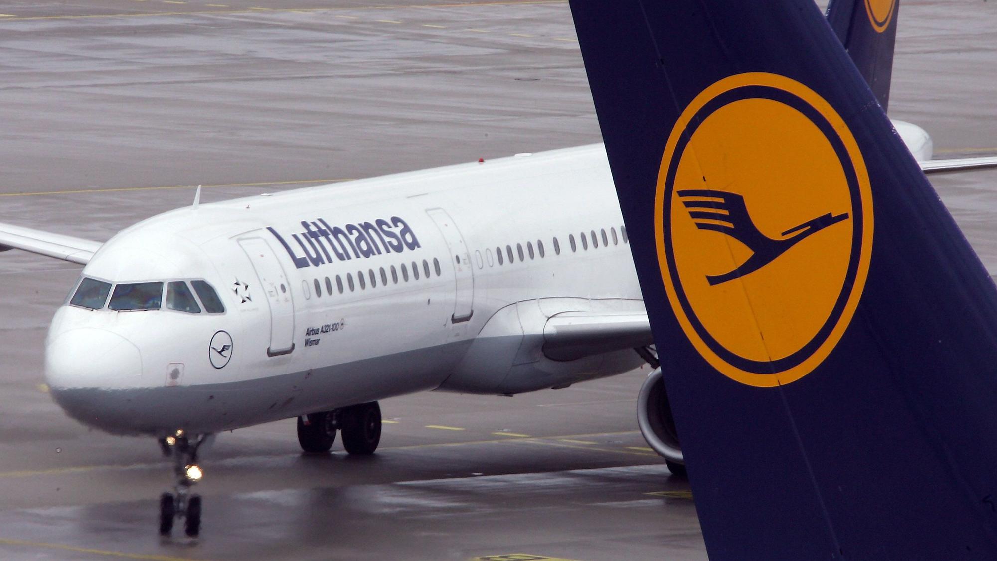 Ein Airbus A321 der deutschen Fluggesellschaft Lufthansa steht auf dem Rollfeld des Flughafens München. Im Vordergrund ist eine Heckflosse eines anderen Flugzeugs mit dem Lufthansa-Logo zu sehen. (Symbolbild)