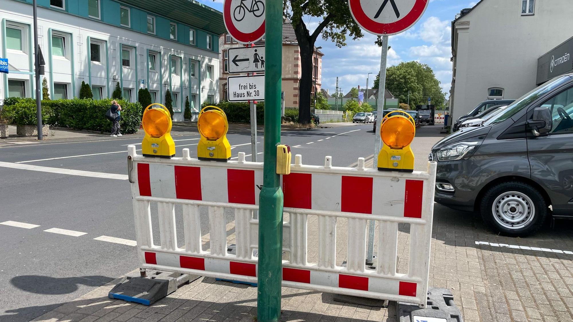 Zahlreiche Schilder weisen auf Sperrungen für Fußgänger und Radfahrer entlang der Manforter Straße bis zur Baustelle an der Fußgängerunterführung hin.