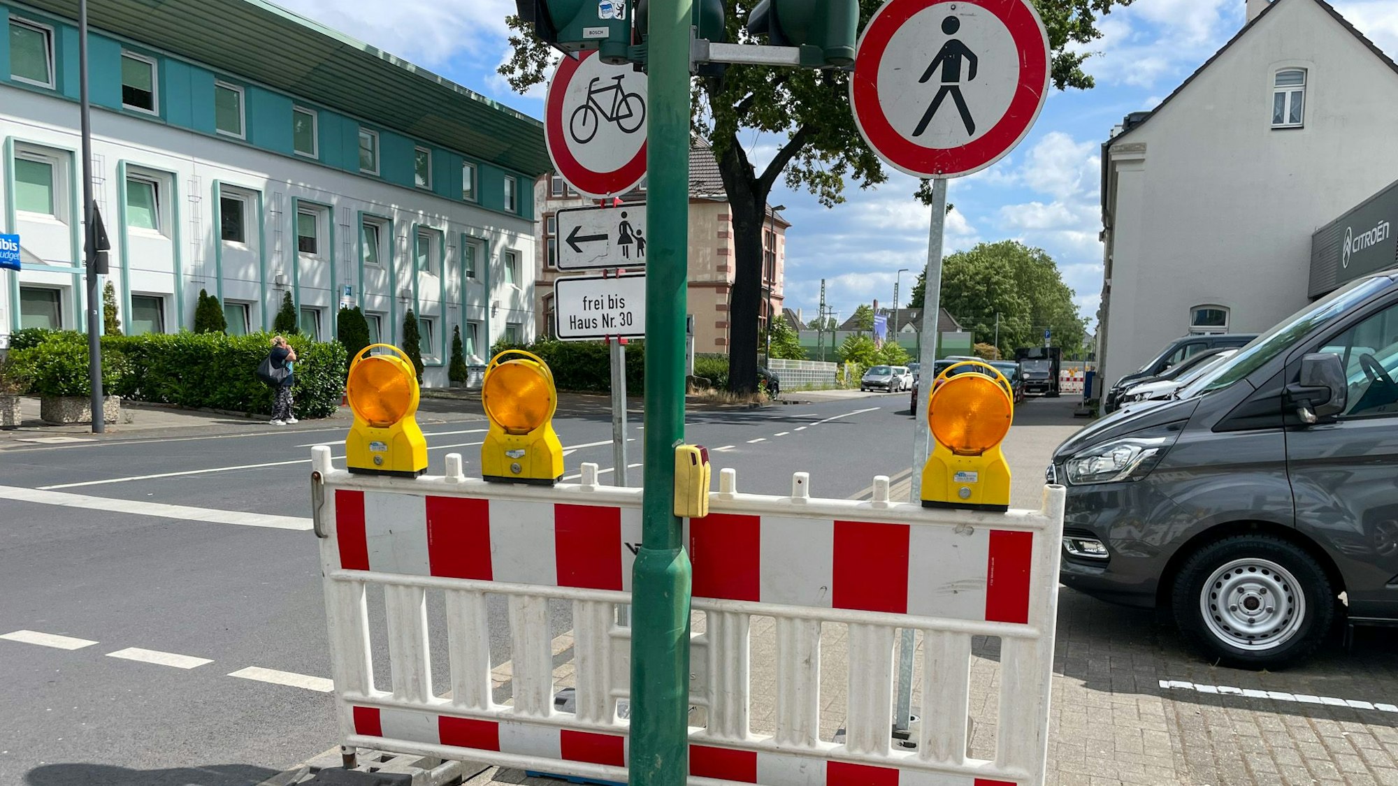 Zahlreiche Schilder weisen auf Sperrungen für Fußgänger und Radfahrer entlang der Manforter Straße bis zur Baustelle an der Fußgängerunterführung hin.