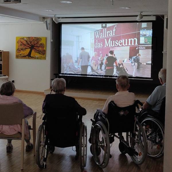 Senioren sitzen bei der digitalen Museumsführung im Burscheider Altenheim Luchtenberg-Richartz-Haus vor der Leinwand.