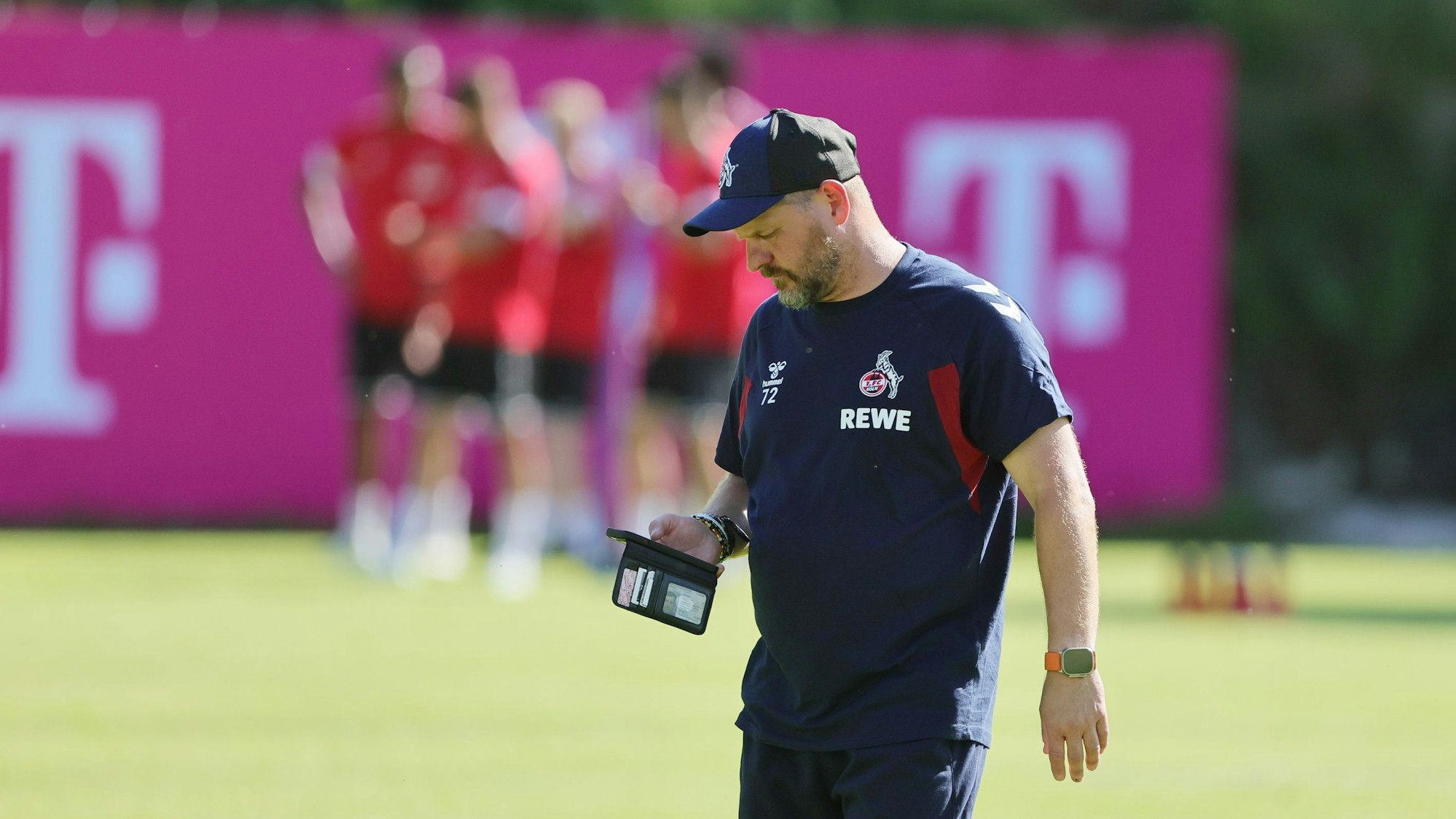 Steffen Baumgart guckt im Trainingslager in Maria Alm aufs Handy