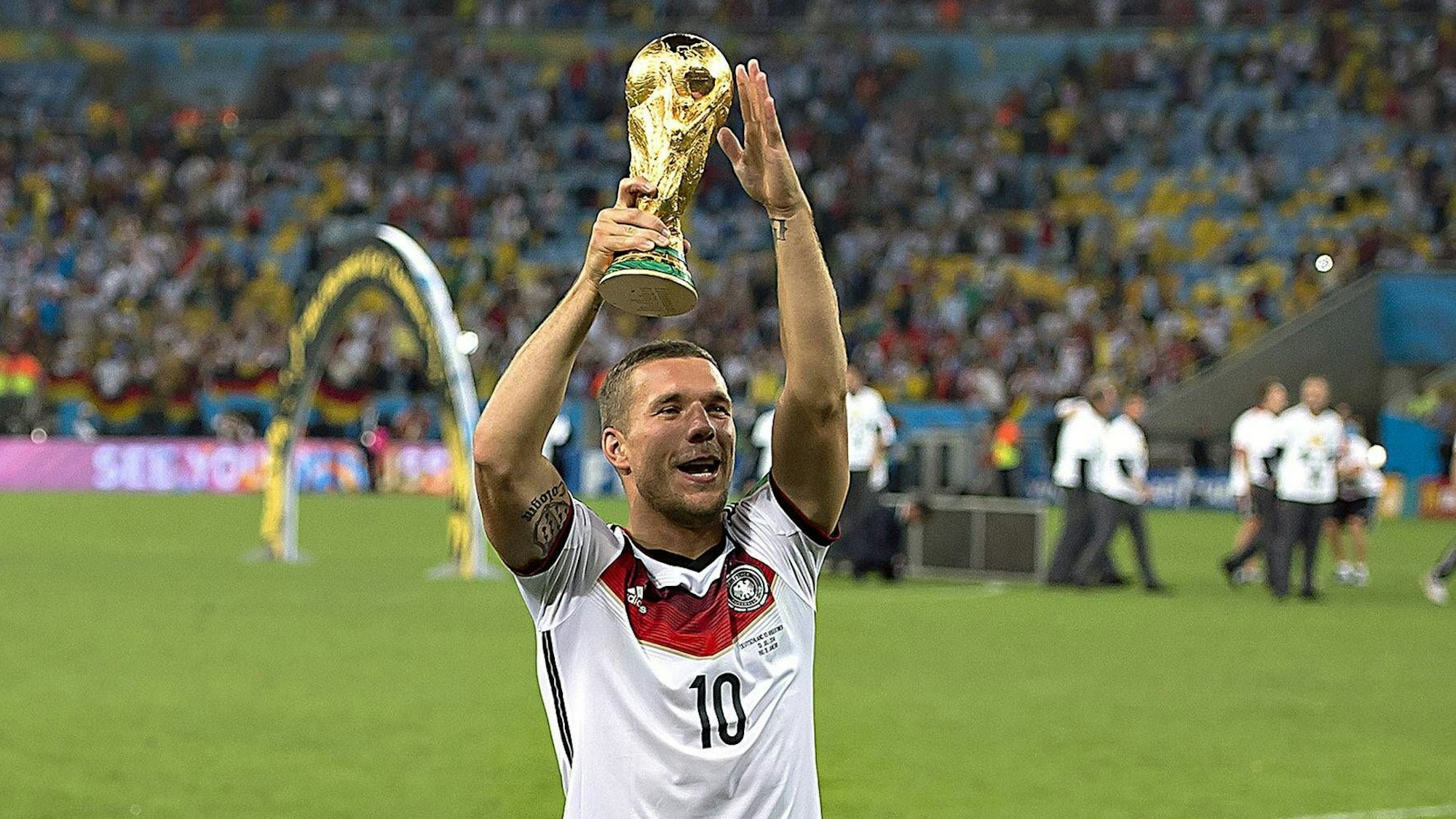 Lukas Podolski feiert mit der WM-Trophäe