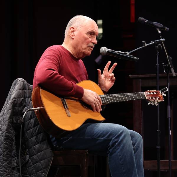 Rolly Brings ist mit Gitarre bei einem Auftritt zu sehen.