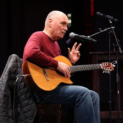 Rolly Brings ist mit Gitarre bei einem Auftritt zu sehen.