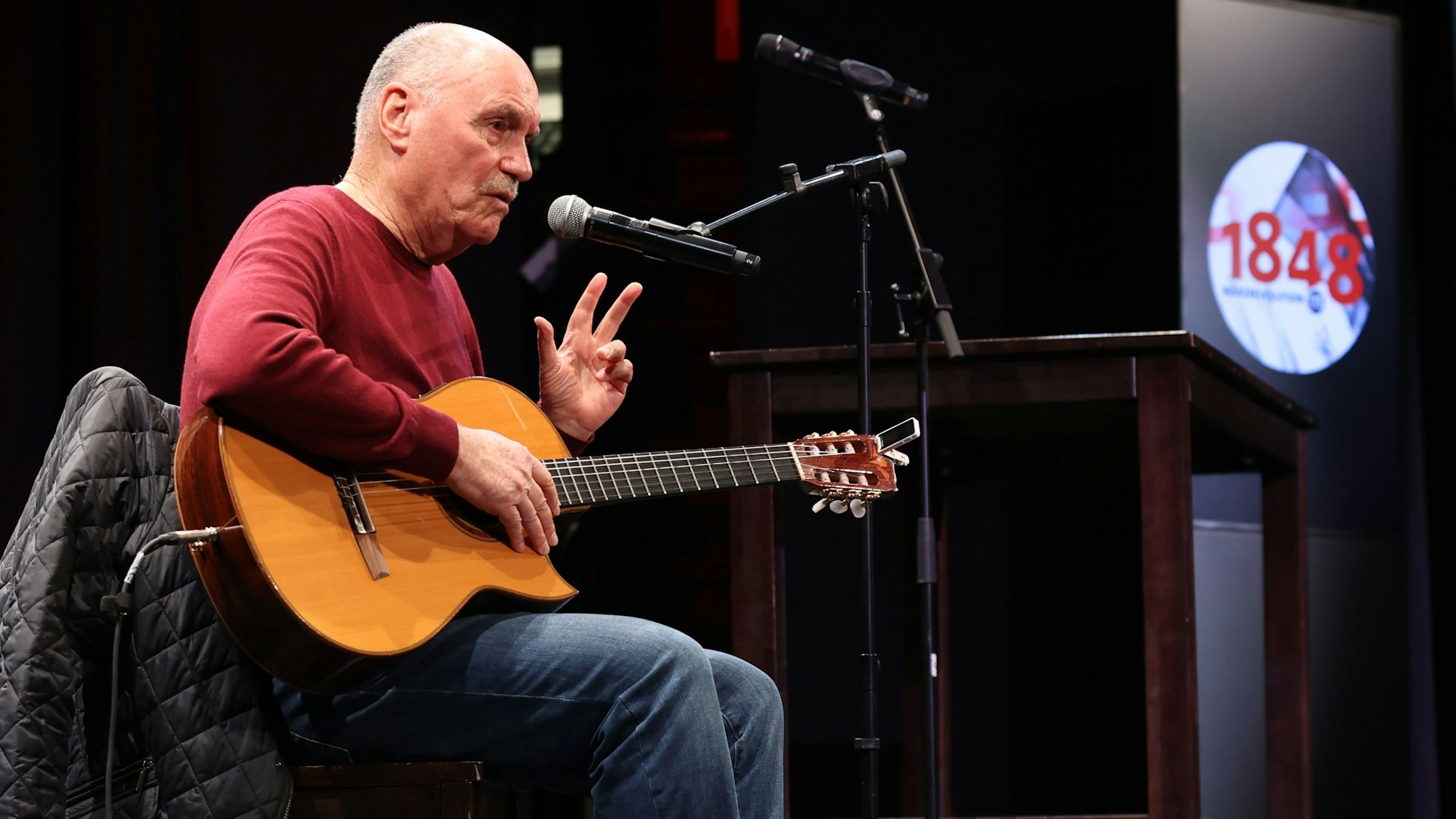 Rolly Brings mit Gitarre auf einer Bühne