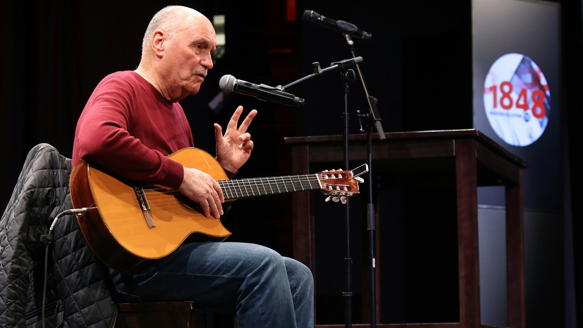 Rolly Brings ist mit Gitarre bei einem Auftritt zu sehen.