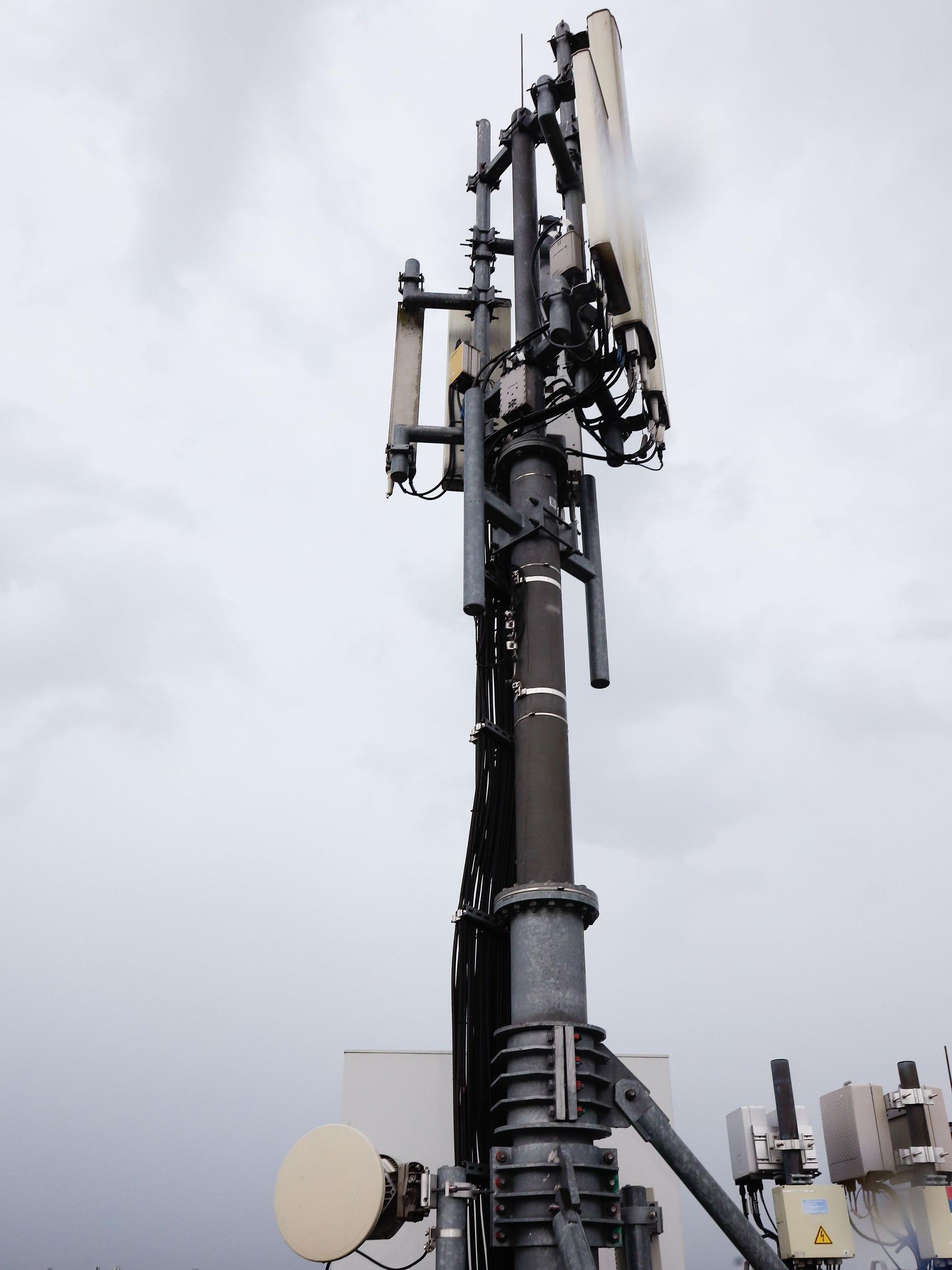 Der Mobilfunkmast in einer Nahaufnahme auf dem Dach des Gebäudes.