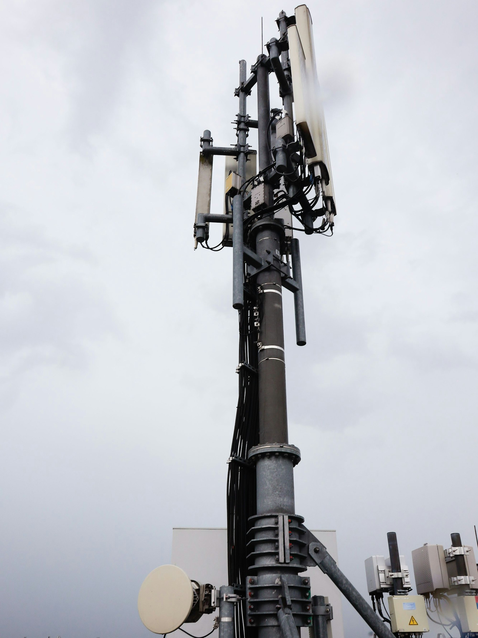 Der Mobilfunkmast in einer Nahaufnahme auf dem Dach des Gebäudes.