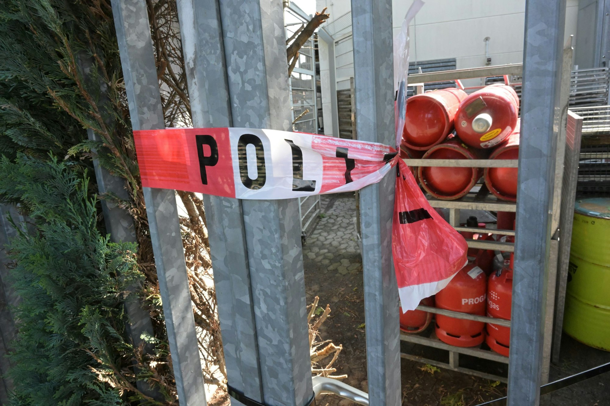 Um Gitterstäbe ist ein Polizei-Absperrband gewickelt.