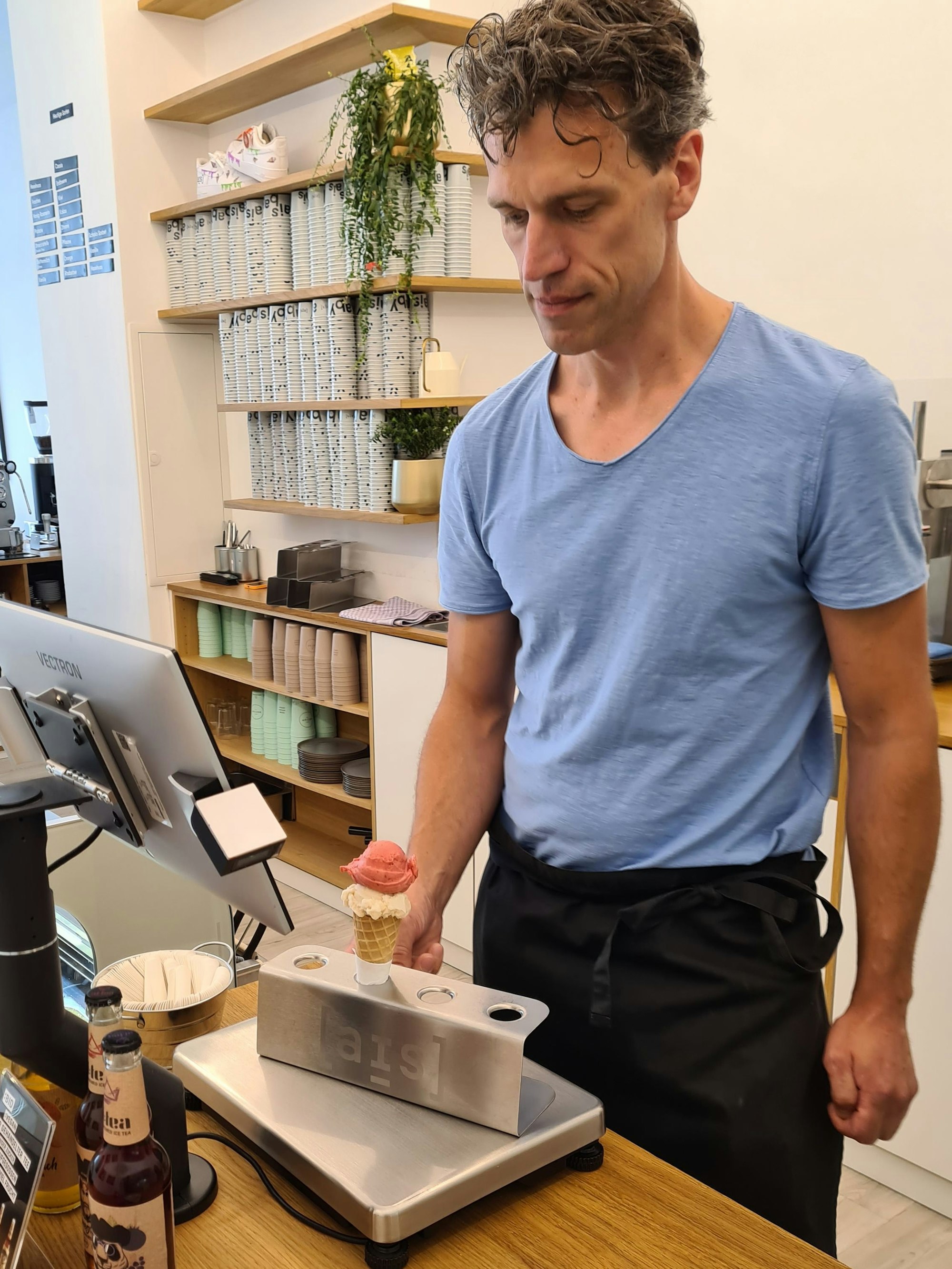 Fabian Spangenberg wiegt das Eis auf der Waage an seiner Kasse.