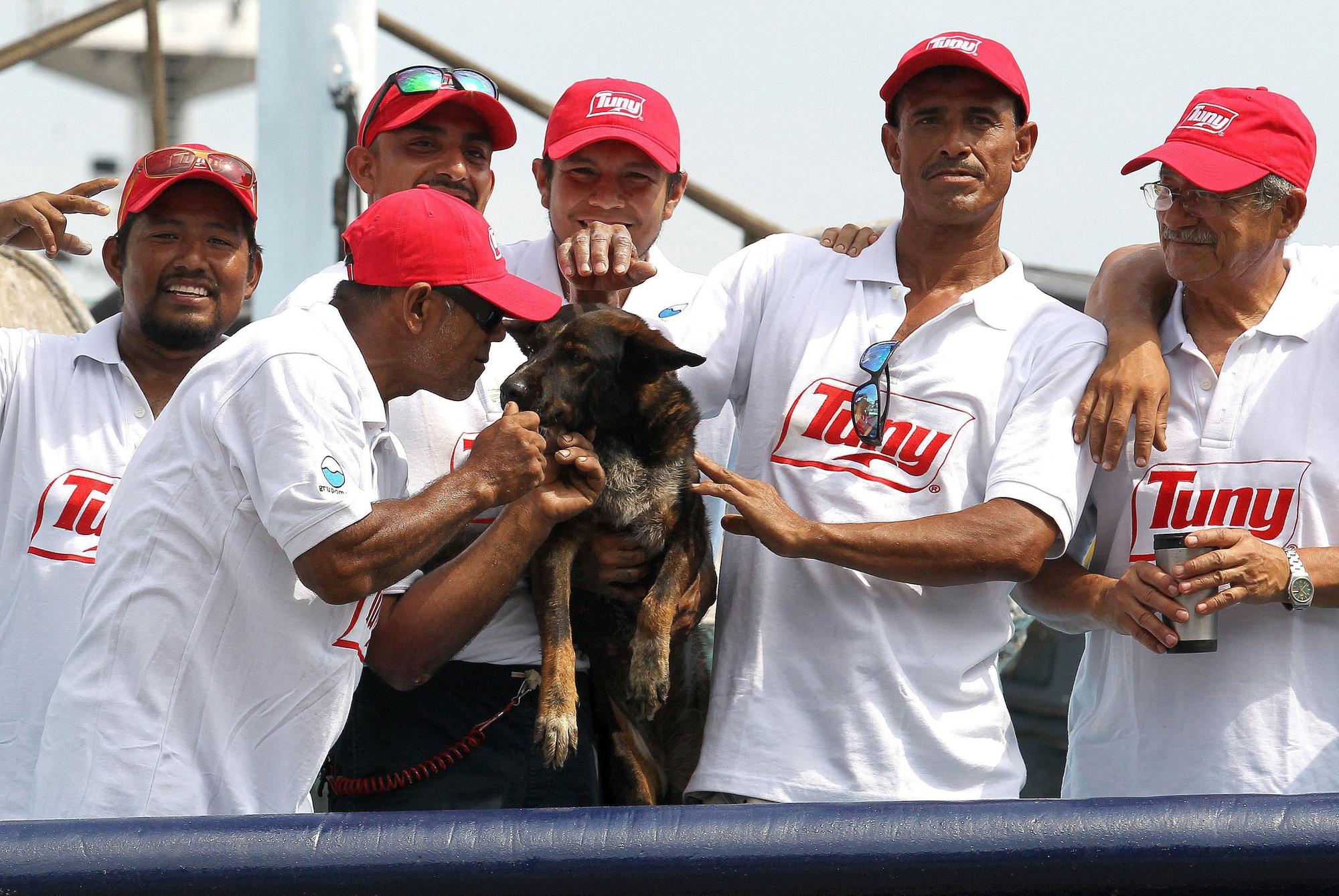 Mitglieder der Crew des mexikanischen Thunfischfängers, die den schiffbrüchigen Australier retteten, posieren mit seinem Hund Bella.