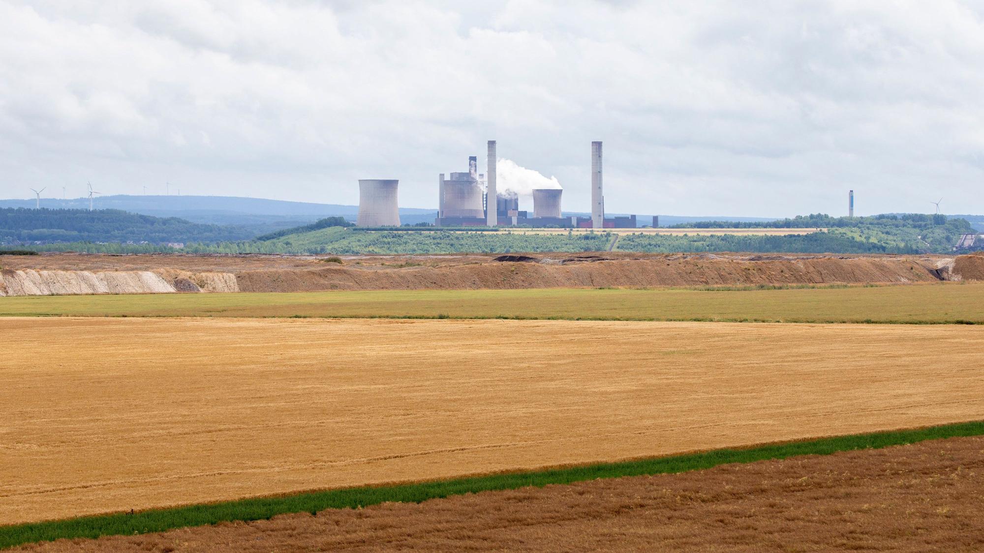 Blick auf den Braunkohletagebau Inden bei Jülich mit landwirtschaftlichen Nutzflächen, im Hintergrund ist das Braunkohlekraftwerk Weisweiler zu sehen.