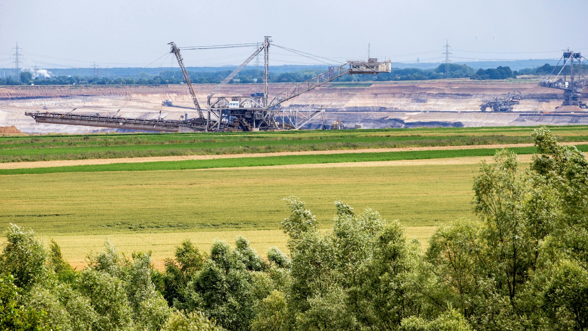 PRODUKTION - 01.07.2023, Nordrhein-Westfalen, Jülich: Blick auf den Braunkohletagebau Inden bei Jülich mit landwirtschaftlichen Nutzflächen im Vordergrund. (zu dpa: Bauern im Rheinischen Revier fürchten Konkurrenz um Flächen) Foto: Thomas Banneyer/dpa +++ dpa-Bildfunk +++