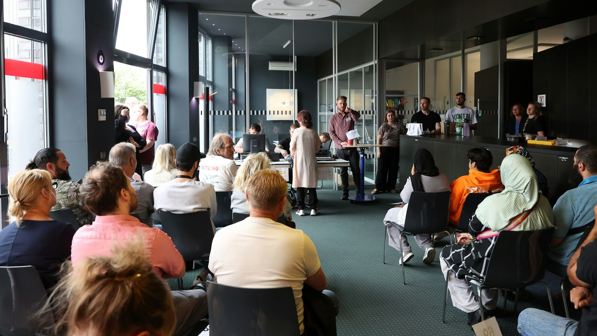 Menschen sitzen im Auktionssaal des städtischen Fundbüros.