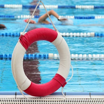 Ein Rettungsring hängt in einem Freibad am Rand des Beckens.