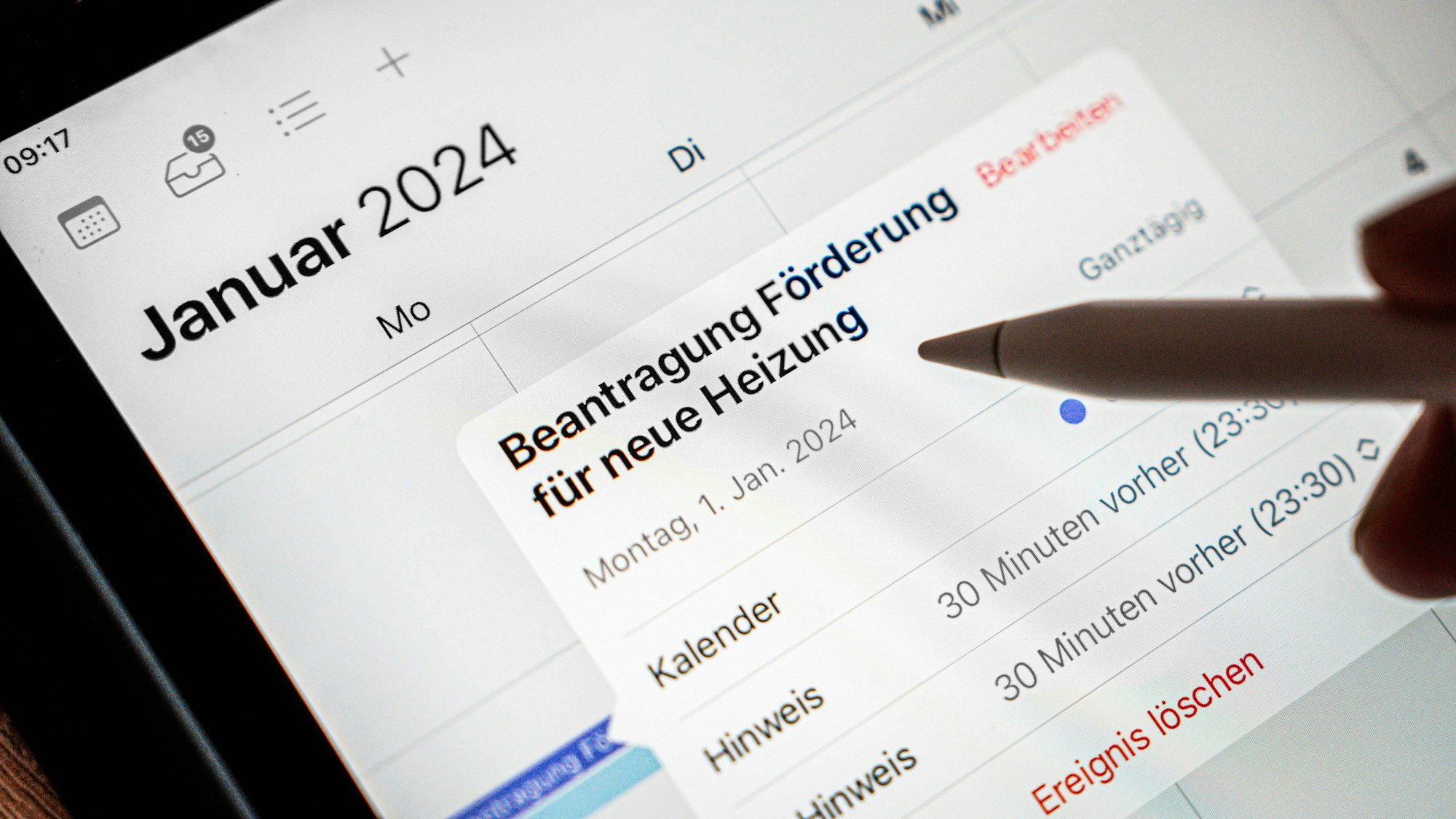 Auf dem Display eines Tablets ist in einem elektronischen Kalender für den 1. Januar 2024 eine Erinnerung eingetragen, die den Titel trägt „Beantragung Förderung für neue Heizung“.
