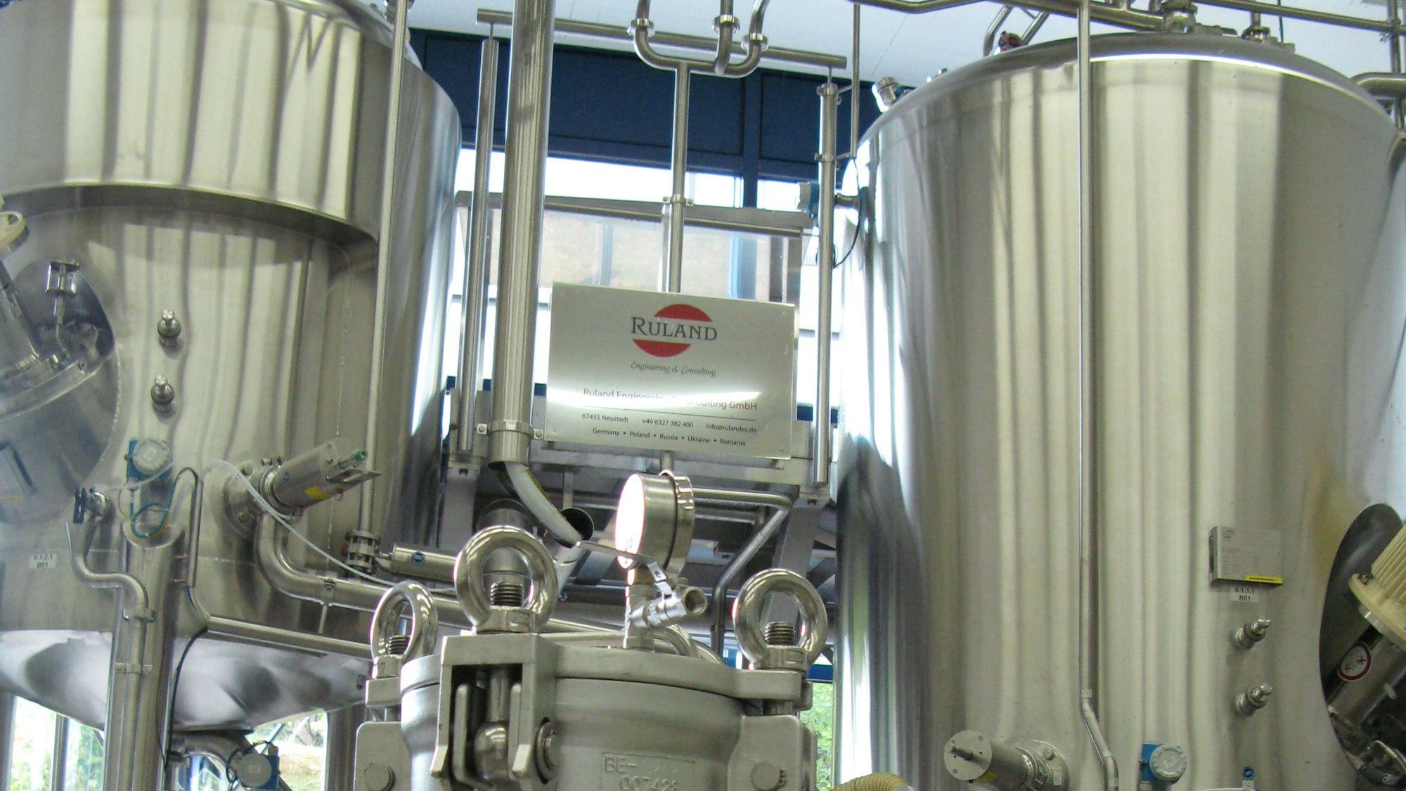 Tanks aus Edelstahl mit Zuleitungen und Messinstrumenten.