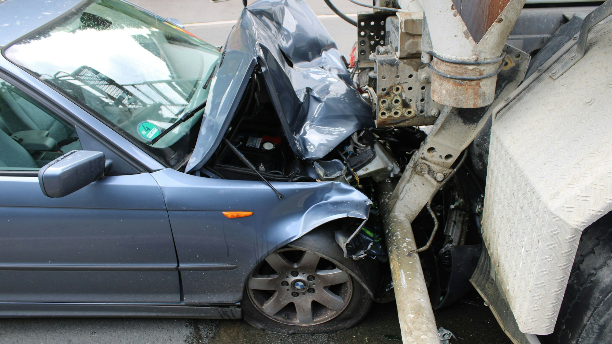 Hoher Sachschaden nach Auffahrunfall in Bergisch Gladbach. Ein BMW ist auf einen Betonmischer aufgefahren.