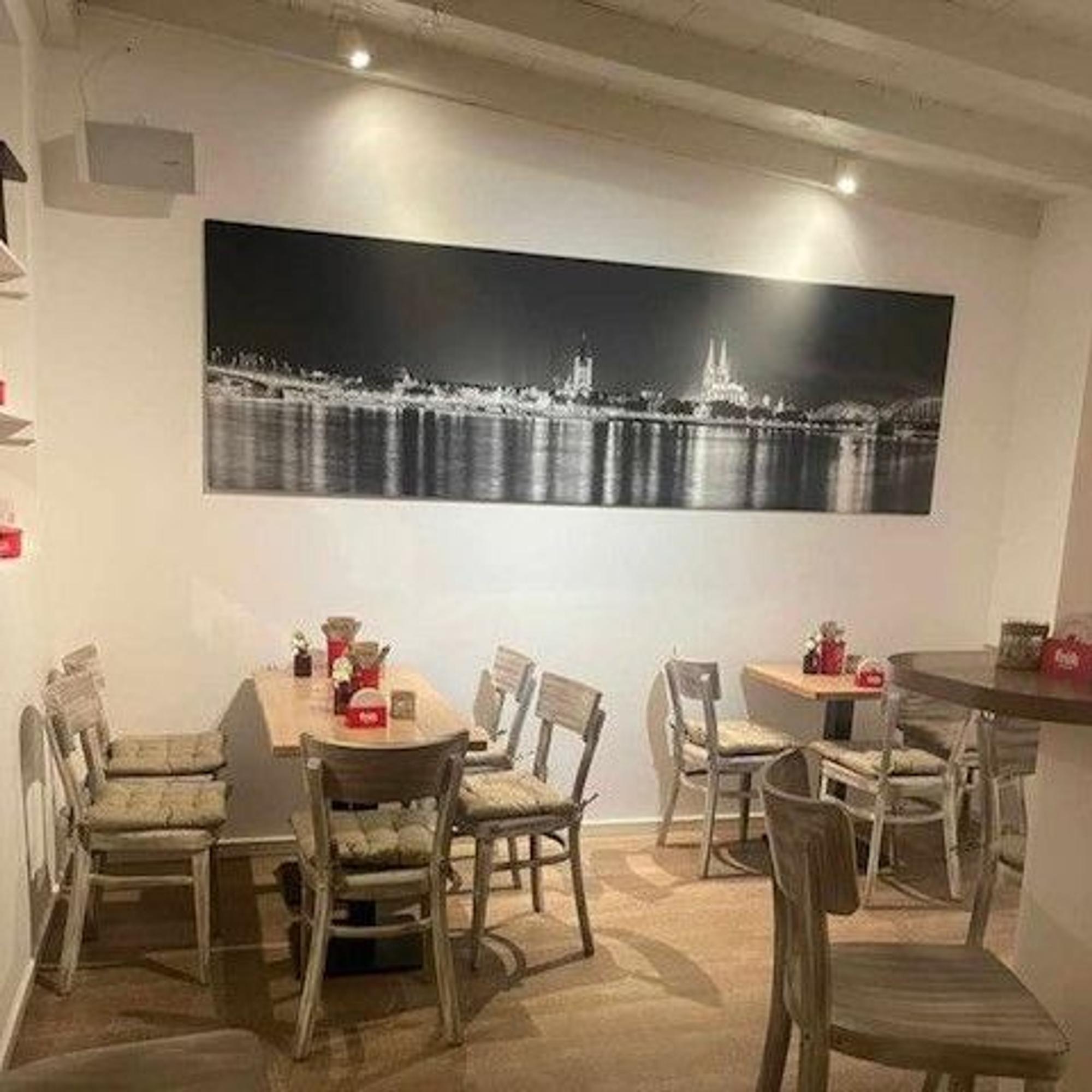 Tische und Stühle stehen im Innenraum des Restaurants.