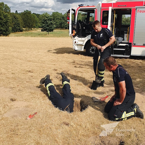 Einsatzkräfte der Feuerwehr retten einen Hund auf einem Sportfeld in Chorweiler aus einem Kaninchenbau.
