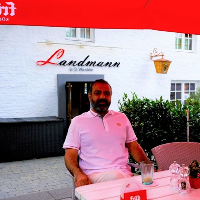 Ein Mann sitzt auf der Terrasse.