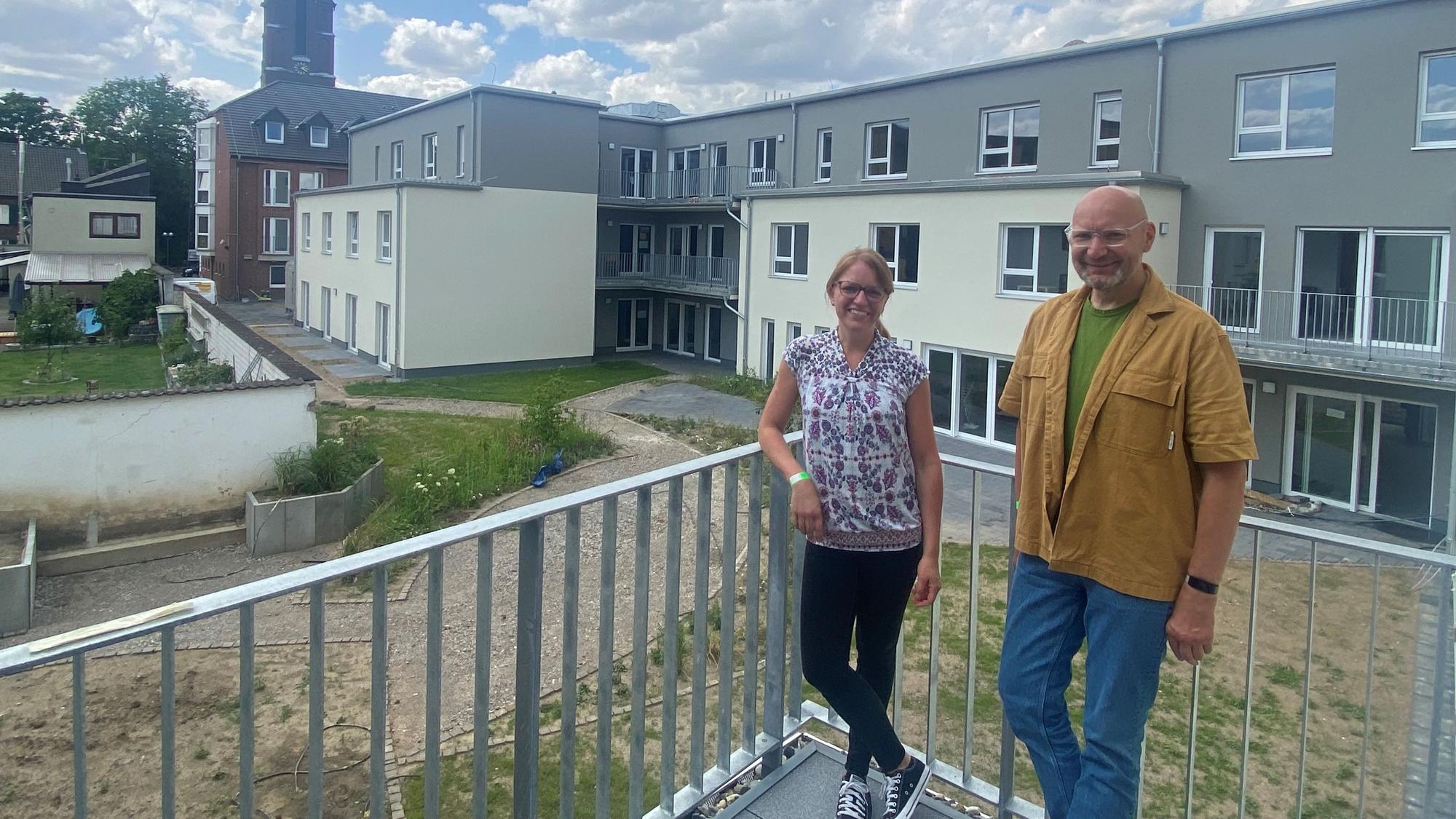 Die beiden Leiter stehen vor dem fertigen Gebäude.