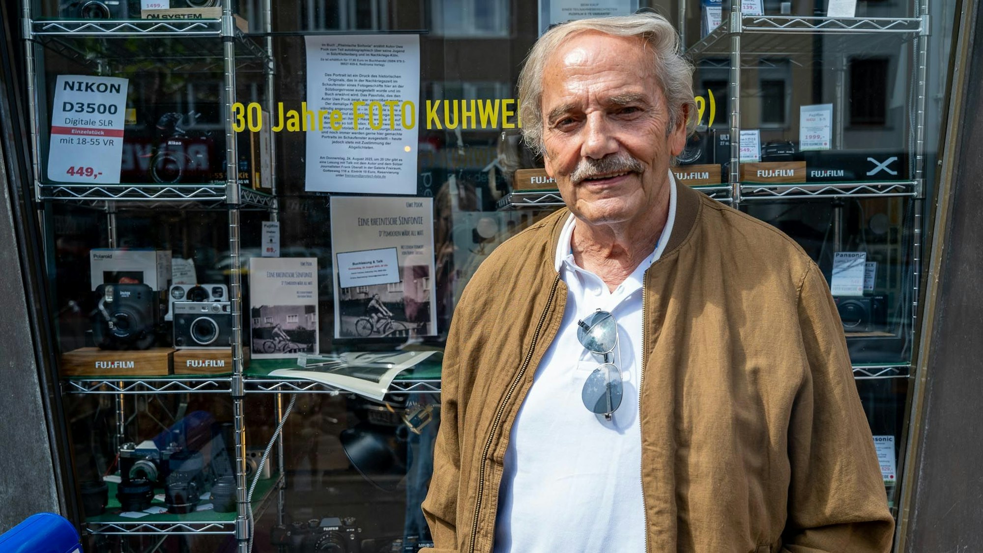 Uwe Pook vor einem Schaufenster eines Kamerageschäfts.