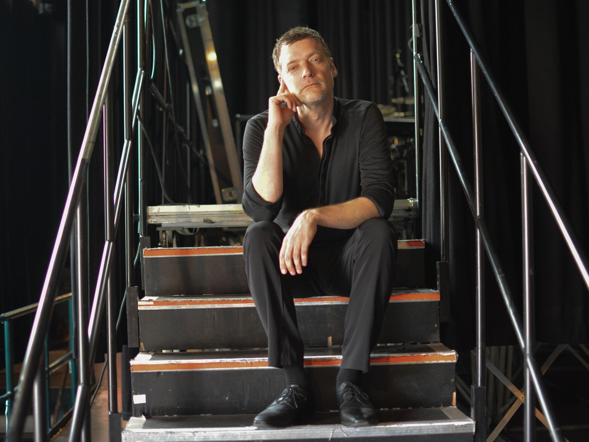Felix Schönfuss sitzt auf der Treppe zur Bühne im E-Werk.