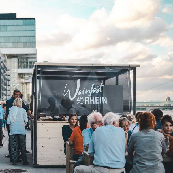 Menschen amüsieren sich beim Weinfest am Kölner Rheinauhafen
