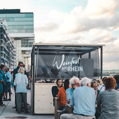 Menschen amüsieren sich beim Weinfest am Kölner Rheinauhafen