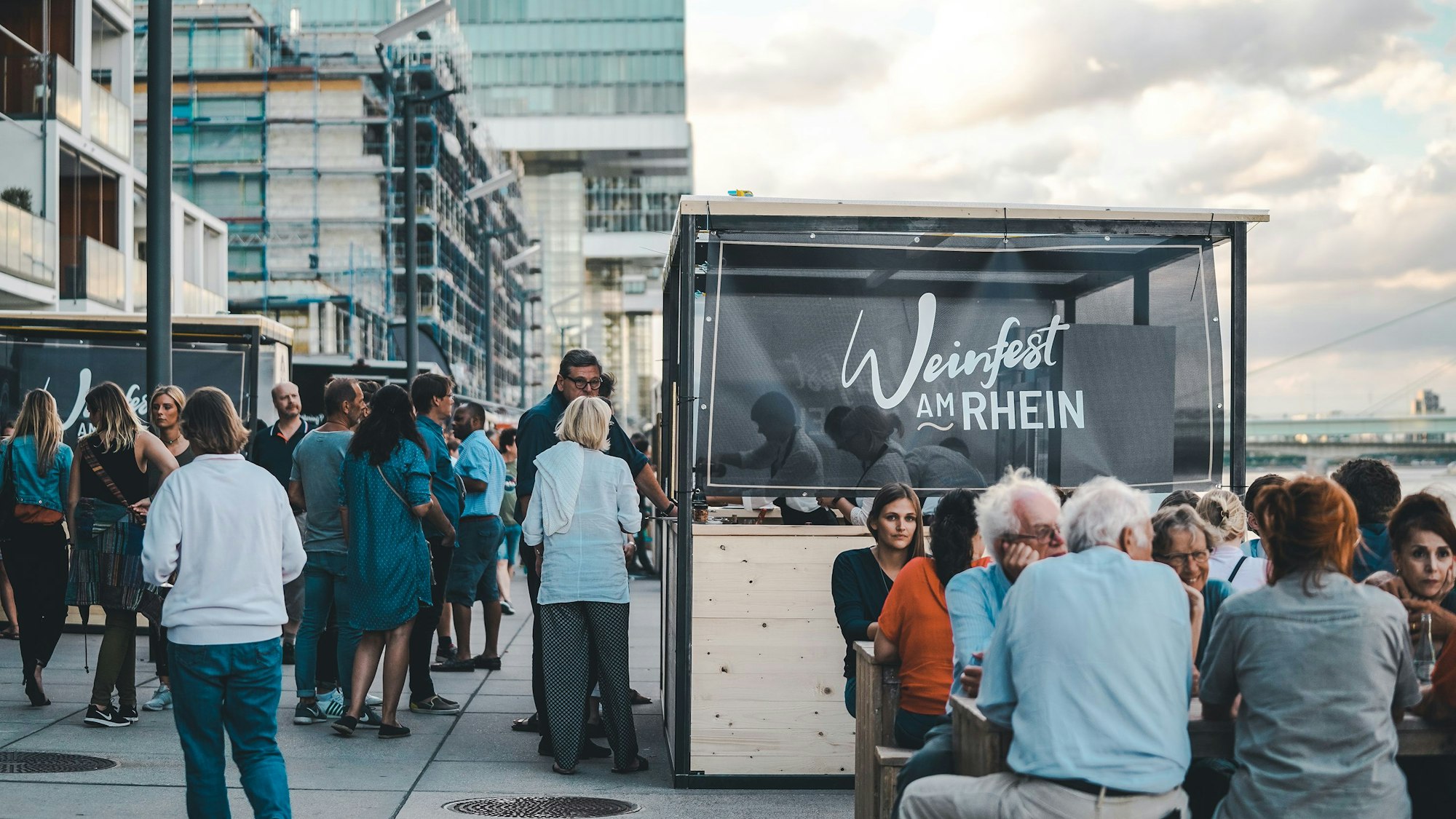 Menschen amüsieren sich beim Weinfest am Kölner Rheinauhafen