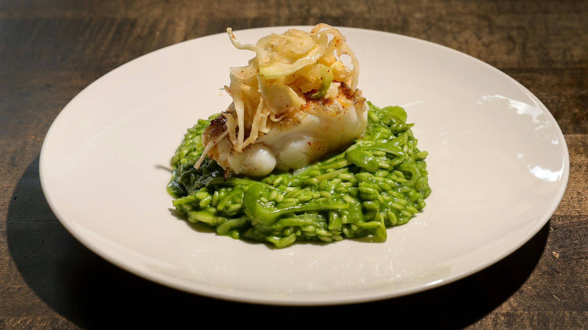Gegrilltes Filet vom Seeteufel mit Fenchel-Risotto und mariniertem Fenchel auf einem Teller angerichtet