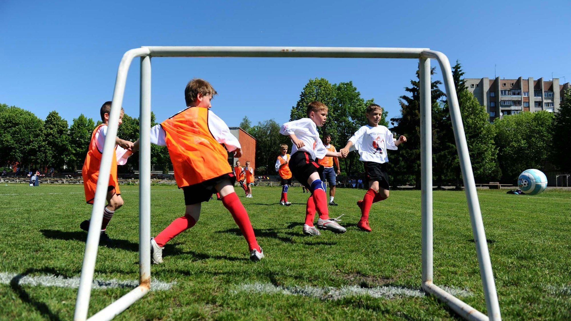 Jungen spielen Fußball auf dem Rasen. Der Ball wild auf das Tor geschossen.