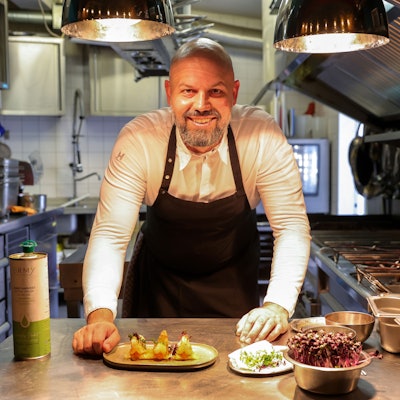 Der Koch Konstantin Tzikas in der Küche seines Restaurants Phaedra mit einem zuebreiteten Gericht.