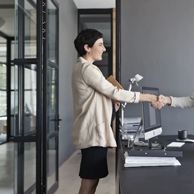 Zwei Frauen schütteln sich die Hände.