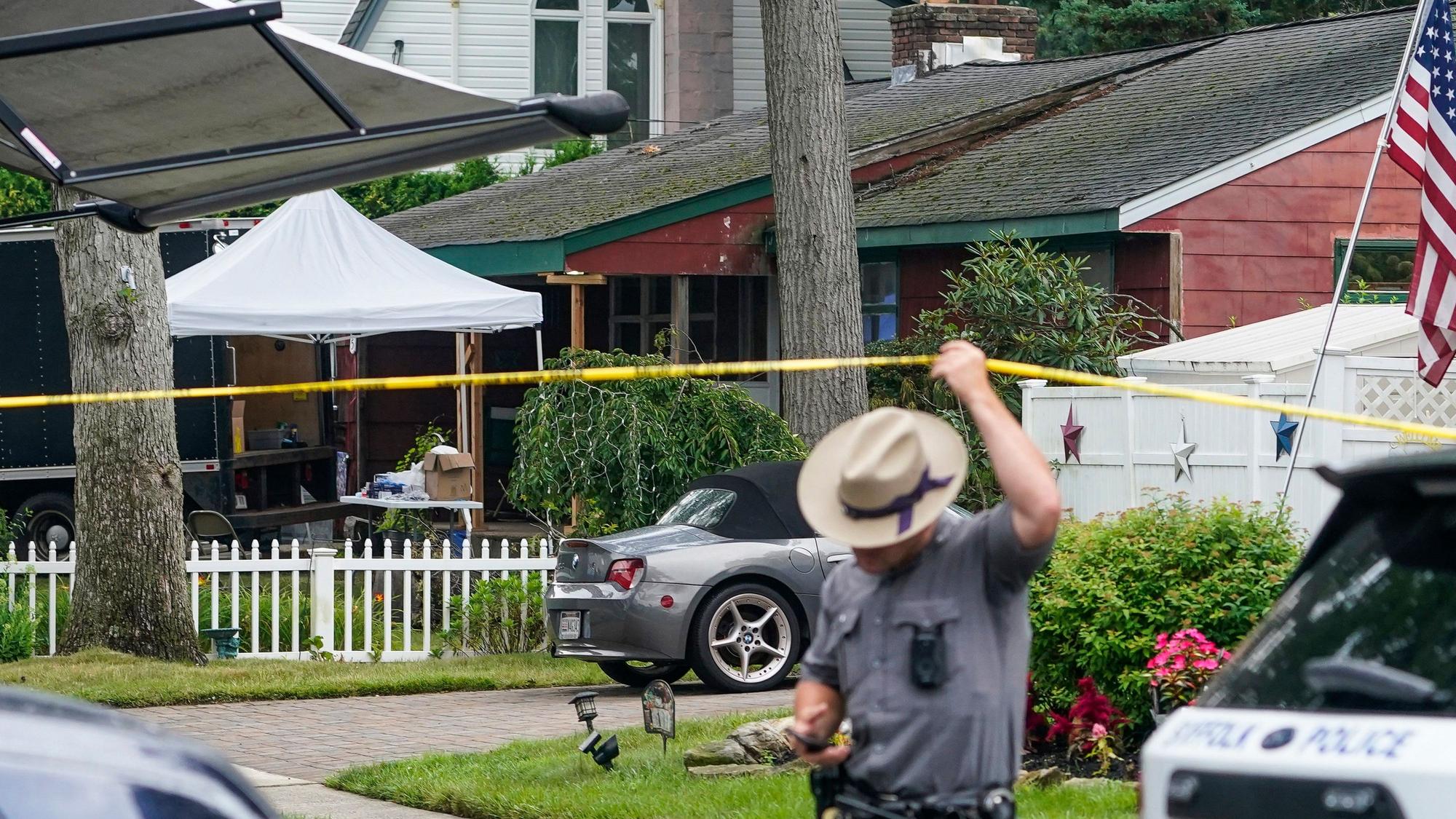 Beamte arbeiten im Freien während der Durchsuchung des Hauses des Verdächtigen Rex Heuermann am Mittwoch, 19. Juli 2023 in New York. Die Polizei transportierte am Dienstag weitere Kisten mit möglichen Beweisen aus Heuermanns Haus auf Long Island.