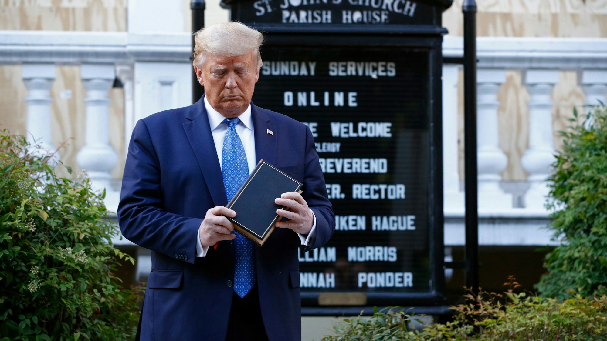 Der frühere US-amerikanische Präsident Donald Trump schaut auf ein Buch, das er in den Händen hält. (Archivbild)