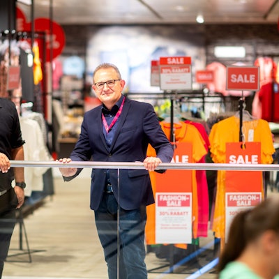 Der neue und der alte Chef der Galeria-Filiale stehen am Geländer.