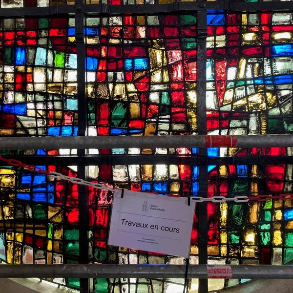 Auf einem Schild in der Pariser Kathedrale Notre-Dame steht „Travaux en cours“ - Bauarbeiten im Gange. Die Kölner Dombauhütte hat vier beim Brand 2019 stark verschmutzte Glasfenster gereinigt, restauriert und jetzt wieder an Ort und Stelle eingebaut.