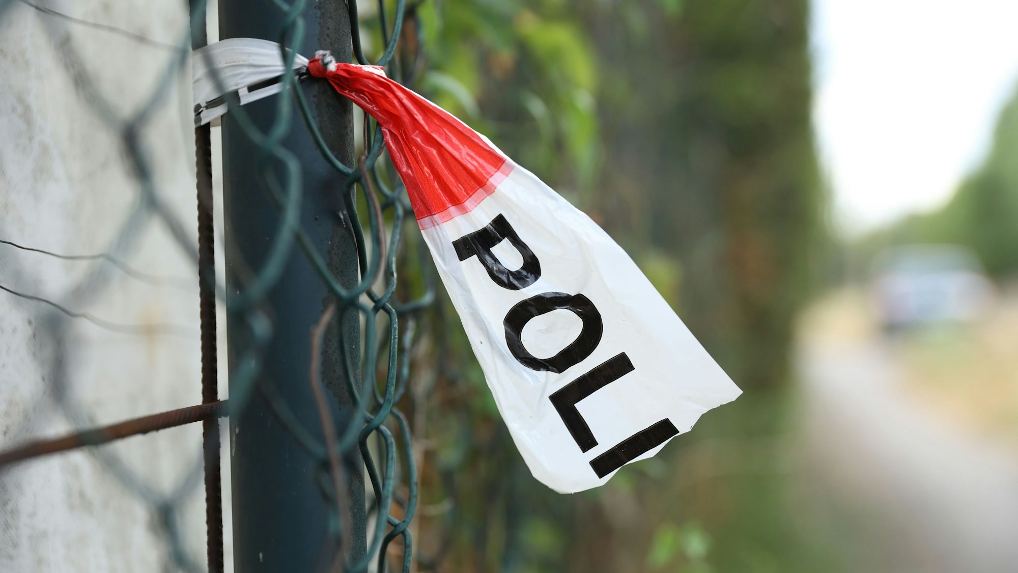 Ein Polizeiabsperrband an einem Zaun.