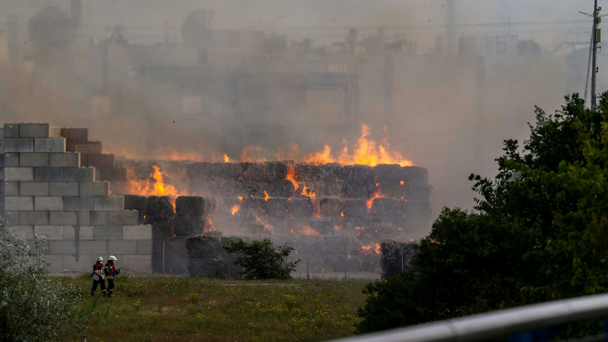 Zusehen sind brennende Altpapierballen.