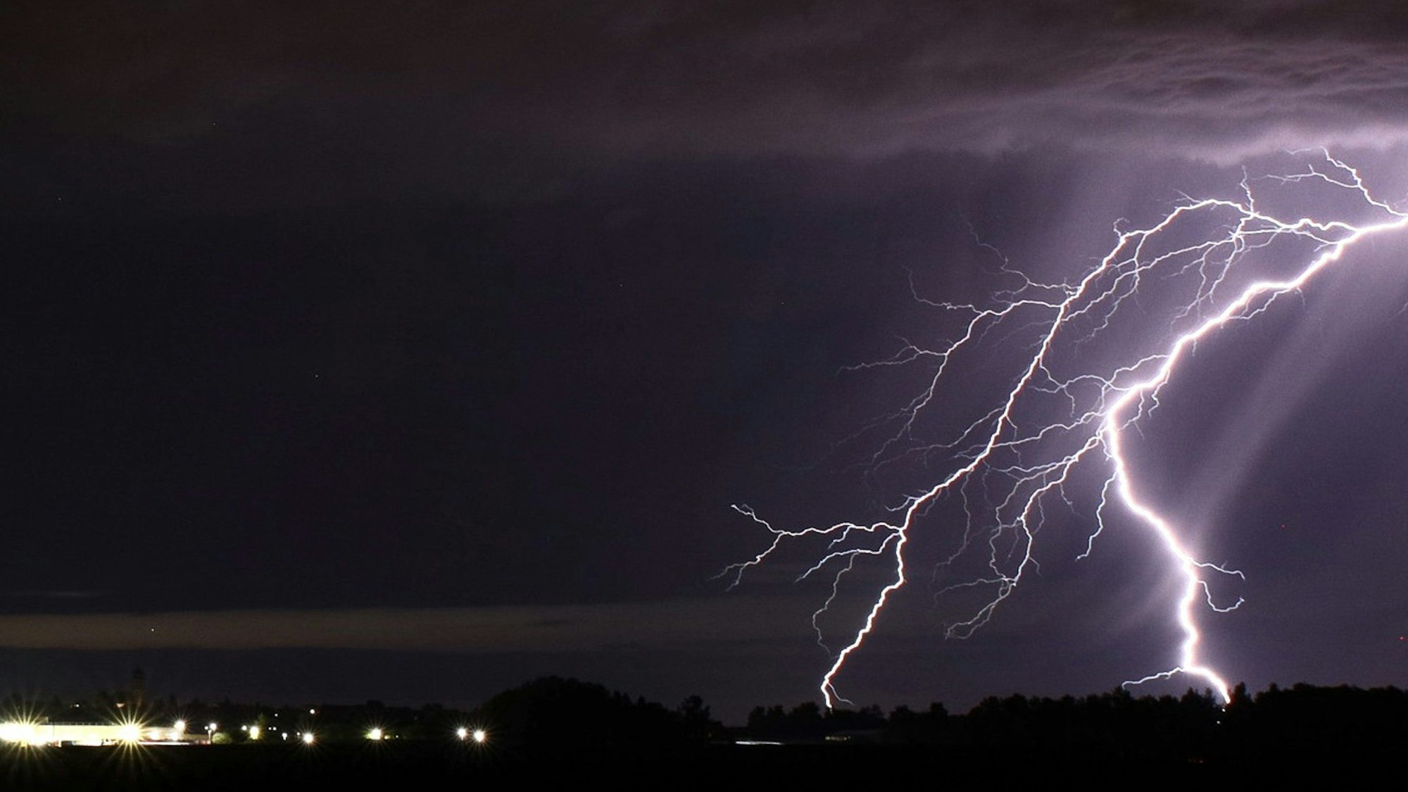 Ein Blitz zuckt bei einem Sommergewitter am nächtlichen Himmel. (Symbolbild)
